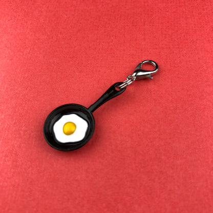 fried egg in black pan charm with clip 